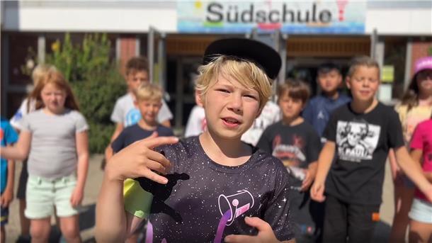 Kinder der Grundschule Süd haben gemeinsam mit Rapper SPAX einen Rapsong zum Thema Zusammenhalt geschrieben.