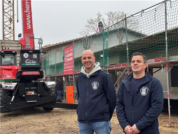 Kirchtimkes Ortsbrandmeister Sven Rugen (rechts) und sein Stellvertreter Jörg Eckhoff stehen vor dem Rohbau des neuen Feuerwehrhauses. Voraussichtlich im Mai 2026 soll das Haus fertig sein.