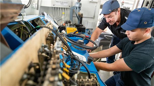 Klaus David (l), Elektriker in Rente, arbeitet mit Johann Müller, Auszubildender zum Mechatroniker.