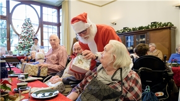 Kleine Bescherung mit liebevoll gepackten Präsenten von fremden Menschen aus Stadt und Landkreis: An der Kaffeetafel der Villa Schocken verteilt der "Weihnachtsmann" - ein Mitarbeiter der AWO - die mit Namen gekennzeichneten Weihnachtsgeschenke.