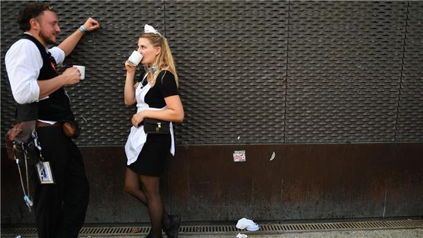Kleine Pause für die Wiesn-Bewirtung: Bedienung Christina und Kellner Cedric  hinter dem Schottenhamel Festzelt auf dem Oktoberfest. 