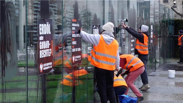 Klimaaktivisten der „Letzten Generation“ beschmieren die gläserne Grundgesetz-Skulptur im Regierungsviertel und kleben Plakate darauf.