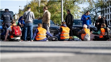 Klimaaktivisten haben sich am Karlsplatz in der Münchner Innenstadt auf die Fahrbahn geklebt und blockieren die Straße.