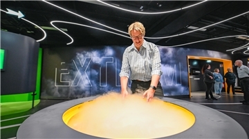Die Geschäftsführerin des Klimahauses, Ingrid Hayen, zeigt ein Exponat der Ausstellung Wetterextreme.