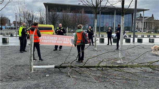 Klimaschutz-Demonstranten fällen Baum am Kanzleramt Klimaschutz-Demonstranten stehen an einem gefällten Baum am Bundeskanzleramt.