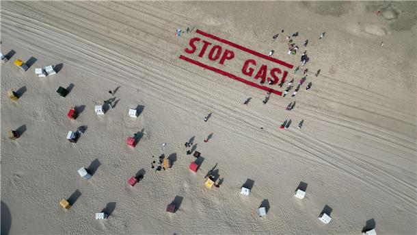 Klimaschutzaktivisten von Fridays for Future schreiben ihre Forderung nach einem Ende der Gasförderung auf den Strand der Insel Borkum. 