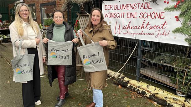 Klimaschutzmanagerin Katharina Koop (links) und Wirtschaftsförderin Katja Beier (rechts) haben die Geestland-Taschen bereits an zahlreiche Einzelhändler verteilt. Eine davon ist Bärbel Pape, die ein Blumengeschäft in Kührstedt führt.