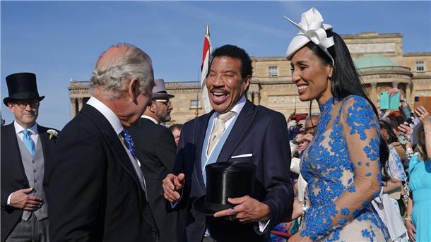 Royale Gartenparty vor Krönung mit prominentem Gast König Charles III. (l) spricht während der Gartenparty im Buckingham Palace mit Lionel Richie (M) und Lisa Parigi.