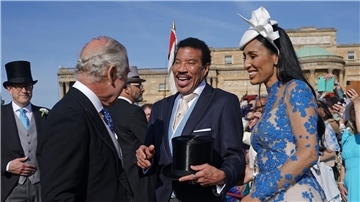 König Charles III. (l) spricht während der Gartenparty im Buckingham Palace mit Lionel Richie (M) und Lisa Parigi.