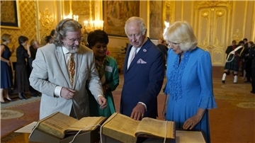 König Charles III. und Königin Camilla betrachten das erste Shakespeare-Folio während eines Empfangs auf Schloss Windsor.