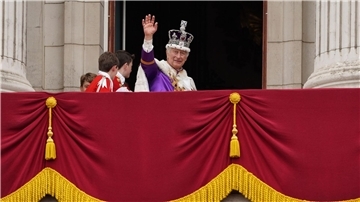König Charles III. winkt nach der Krönungszeremonie vom Balkon des Buckingham-Palastes.