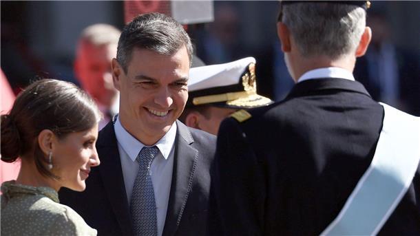 Königin Letizia (l-r), Pedro Sanchez, Ministerpräsident von Spanien, und König Felipe VI. sprechen am Rande einer Militärparade.