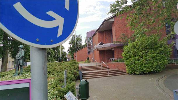 Nordenham: Darum soll die Stadthalle Friedeburg nun doch nicht ersetzt werden Im Vordergrund ist ein Verkehrsschild zu sehen, dahinter ein größeres Gebäude.