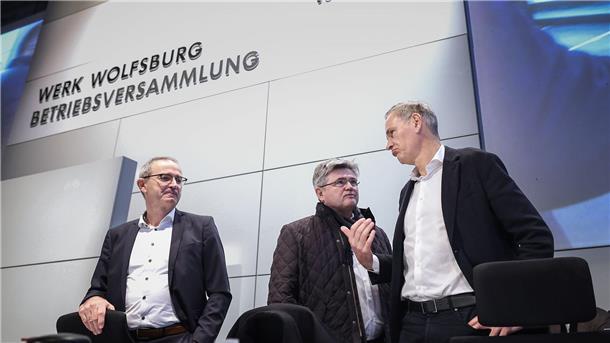 Konzernchef Oliver Blume (r.) berät sich vor seiner Rede mit  VW-Verhandlungsführer Arne Meiswinke (Mitte).