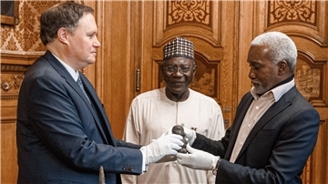 Kultursenator Carsden Brosda (SPD, l-r), der Generaldirektor der Nationalen Behörde für Museen und Denkmäler in Nigeria Abba Isa Tijani und Botschafter Yusuf Matama Tuggur vollziehen eine symbolische Übergabe.