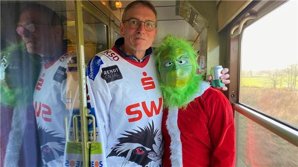 Liveticker: Pinguins-Sonderzüge erreichen Köln Kurz vor Weihnachten war ein besonderer Gast an Bord: der Grinch (hier mit Pinguins-Fan Jörg). Er zog durch die Abteile und Gänge und triezte die Pinguins-Fans