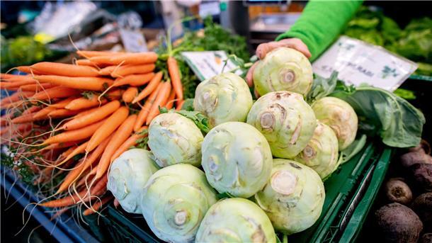 Diese Facebook-Gruppe vernetzt Hofläden und Käufer im Cuxland  Kohlrabi und Karotten stehen an einem Obst- und Gemüsestand auf einem Wochenmarkt zum Verkauf.