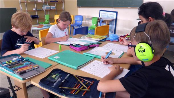 Vier Schüler an zwei Tischen