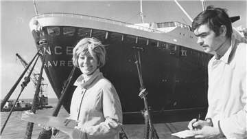 Lale Anderson vor einem Schiff mit Reporter.