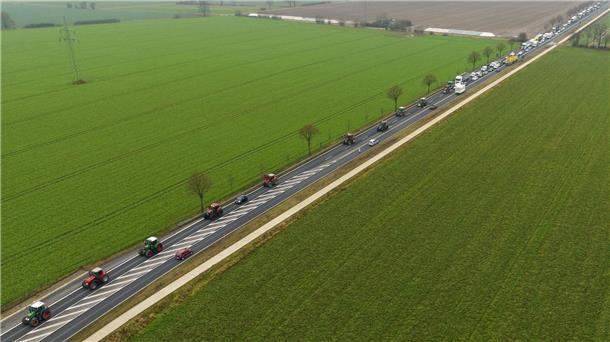 Bauernproteste reißen nicht ab Landwirte fahren mit ihren Traktoren im Schritttempo über eine Bundesstraße.
