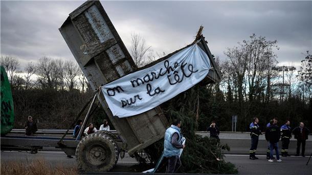 Landwirte kippen Zweige und Äste auf die Fahrbahn, während sie eine Autobahn in der Nähe von Lyon blockieren.