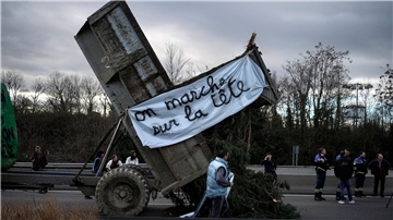 Landwirte kippen Zweige und Äste auf die Fahrbahn, während sie eine Autobahn in der Nähe von Lyon blockieren.