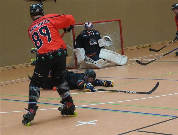 Ein Inlineskater-Hockeyfahrer schießt aufs Tor.
