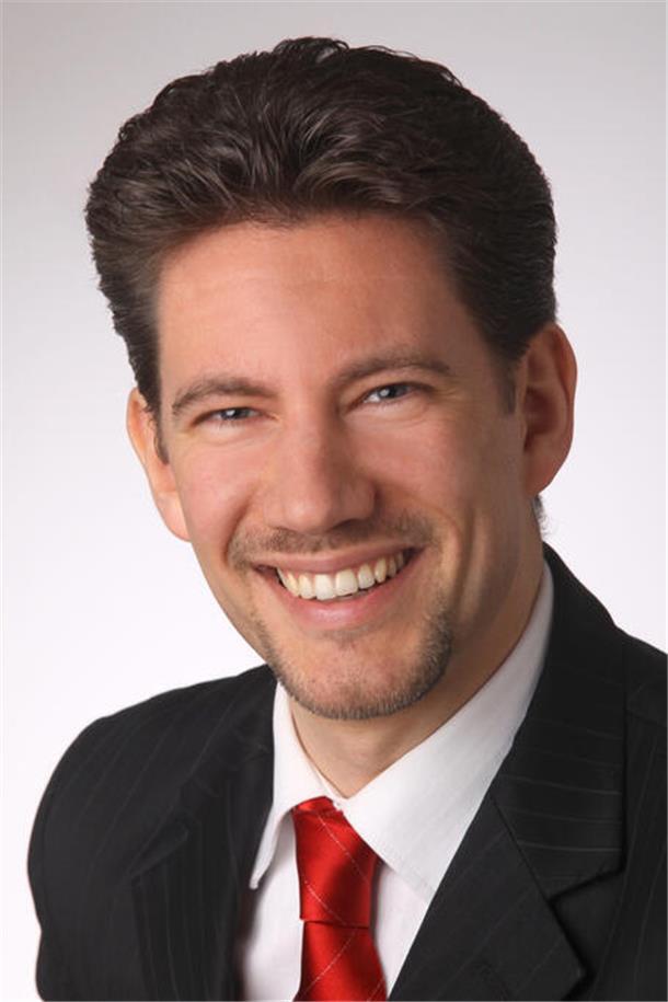 Ein Mann lächelt in die Kamera. 