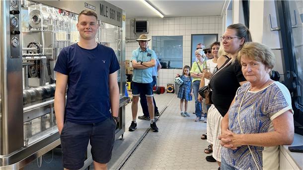 Eine Besuchergruppe schaut sich eine Füllanlage an.
