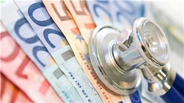 Ein Stethoskop liegt auf mehreren Euro-Scheinen