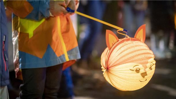 Ein Kind hält eine Laterne in der Hand.