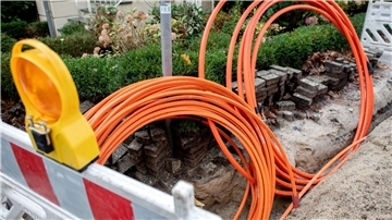 Leerrohre für neue Glasfaserkabel liegen auf einer Baustelle.