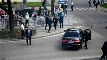 Leibwächter bringen den slowakischen Ministerpräsidenten Robert Fico in einem Auto vom Ort des Geschehens in Sicherheit.