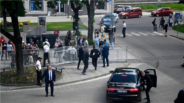 Regierungschef Fico nach Attentat weiter in Lebensgefahr Leibwächter bringen den slowakischen Regierungschef Robert Fico nach dem Attentat in einem Auto in Sicherheit.