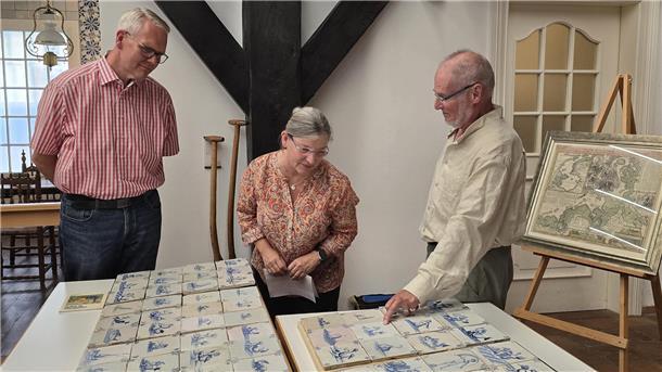 Zwei Männer und eine Frau mit wertvollen historischen Fliesen