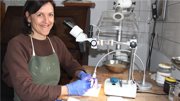 Lena Geidner am Mikroskop in ihrer Werkstatt für Restaurierung in Vorwerk.