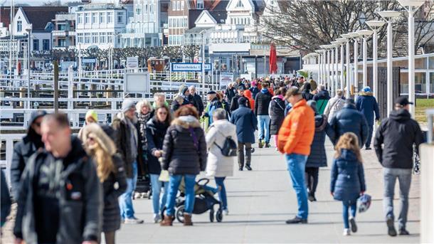 Leute sind am Samstagvormittag auf der Promenade von Travemünde unterwegs.