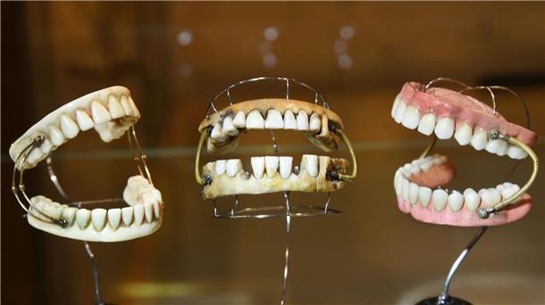 Dentalmuseum zeigt Skurriles und Religiöses Links ein vollständiges Gebiss aus Elfenbein geschnitzt mit einer Doppelfeder versehen aus der Zeit um 1750, in der Mitte ein sogenanntes Waterloo Gebiss, welches einem Menschen etwa 5 bis 10 Jahre seine Dienste geleistet hat und rechts ein Kautschuckgebiss mit Federn um 1870.
