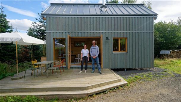 Lisa Gelzhäuser (l) und Timo Gelzhäuser (r) stehen vor einem Muster ihres Tiny Houses: Es sind viele weitere Größen, Varianten, Erweiterungen und Dachformen möglich.