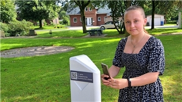 Lisanne Schröter (14) aus Bokel testet den neuen QR-Code an der Stele in Bokel. Die Schülerin hat selbst Texte eingelesen, die vor Ort auf einer Audio-Datei auf das Smarphone heruntergeladen werden können. 