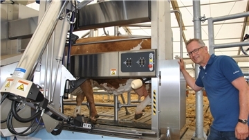 Live-Melken in Tarmstedt: Uwe Meyenburg, DeLaval-Verkaufsleiter für die Region, erklärt dem Messepublikum, wie der Melkroboter funktioniert.