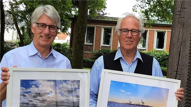 Lutz Ackermann (rechts) fotografiert immer, wenn er mit der Fähre von Sandstedt übersetzt. Bürgermeister Michael Kurz hat den Moderator überredet, die so entstandenen Fotos im Rathaus auszustellen.