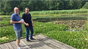 Lutz Becker (links) vom Bremerhavener Umweltschutzamt und Jörg Bruse von den Entsorgungsbetrieben kontrollieren den Auesee in Bremerhaven-Speckenbüttel.