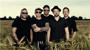 Männer in schwarzer Kleidung stehen in einem Kornfeld. Macsat aus Münster sind in diesem Jahr der Headliner bei „Nordenham rockt bunt“.