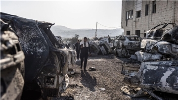Männer gehen in Huwara an verbrannten und zerstörten Fahrzeugen vorbei. Nach einem tödlichen Anschlag auf zwei Israelis war es dort zu schweren Ausschreitungen israelischer Siedler gekommen.