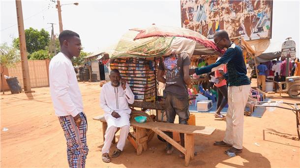 Putsch im Niger beunruhigt Paris - Lage weiter prekär Männer stehen auf einem Straßenmarkt in Niamey.