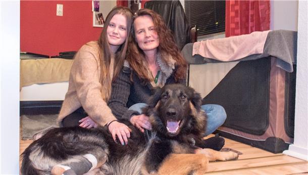 Zwei Frauen streicheln einen Hund.