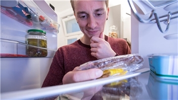 Ein Mann blickt in den Kühlschrank