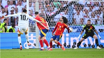 Marc Cucurella stoppt den Schuss von Jamal Musiala (l) mit seinem Arm.