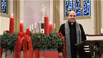 Ein Pfarrer steht in der Kirche.